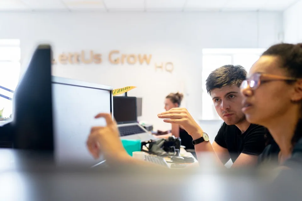 Engineering colleagues discussing work at computer screens