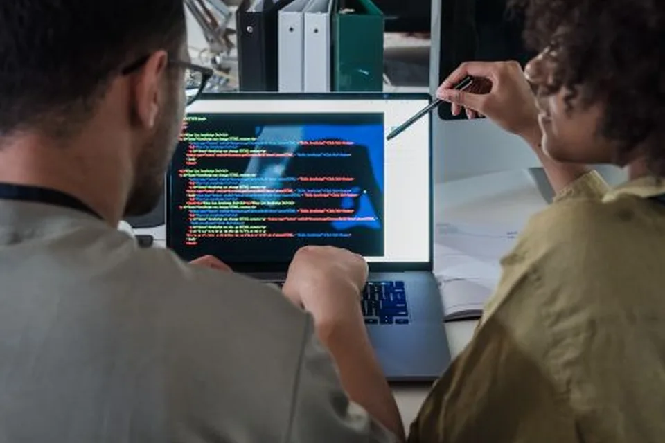 Software developers collaborating on a laptop