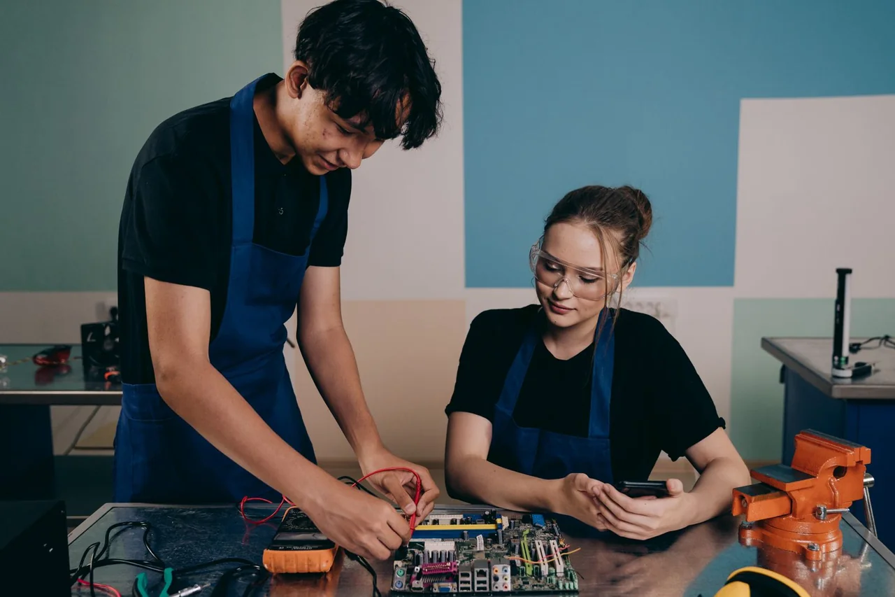 Electronics engineers examining and testing a circuit board